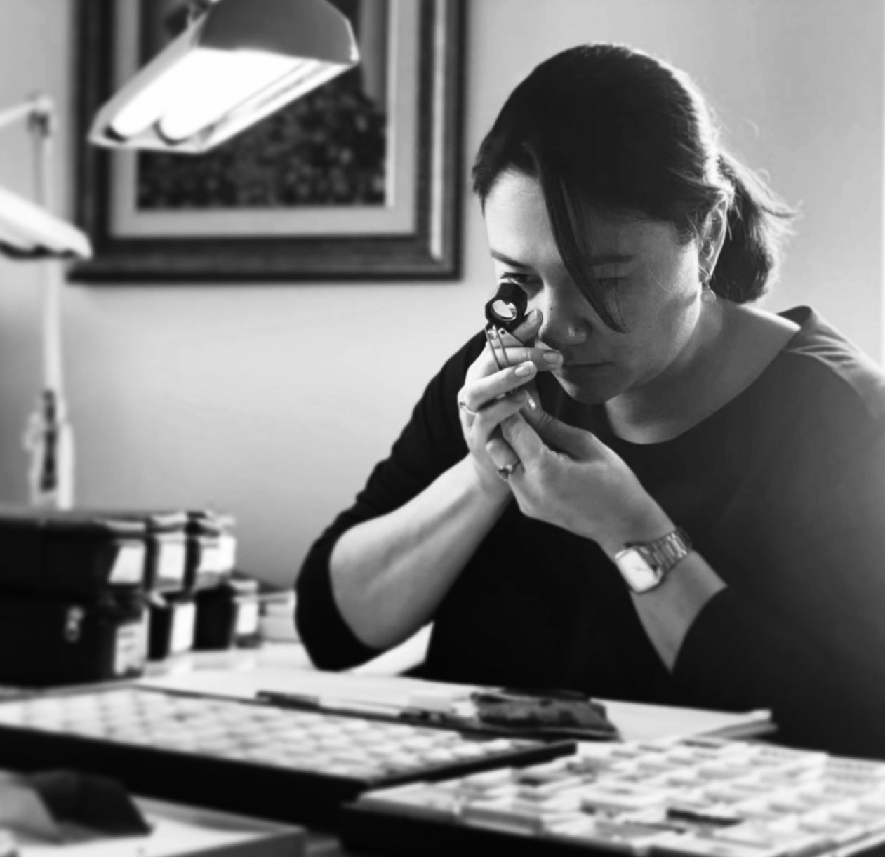 A gemmologist inspects a gemstone under a loupe